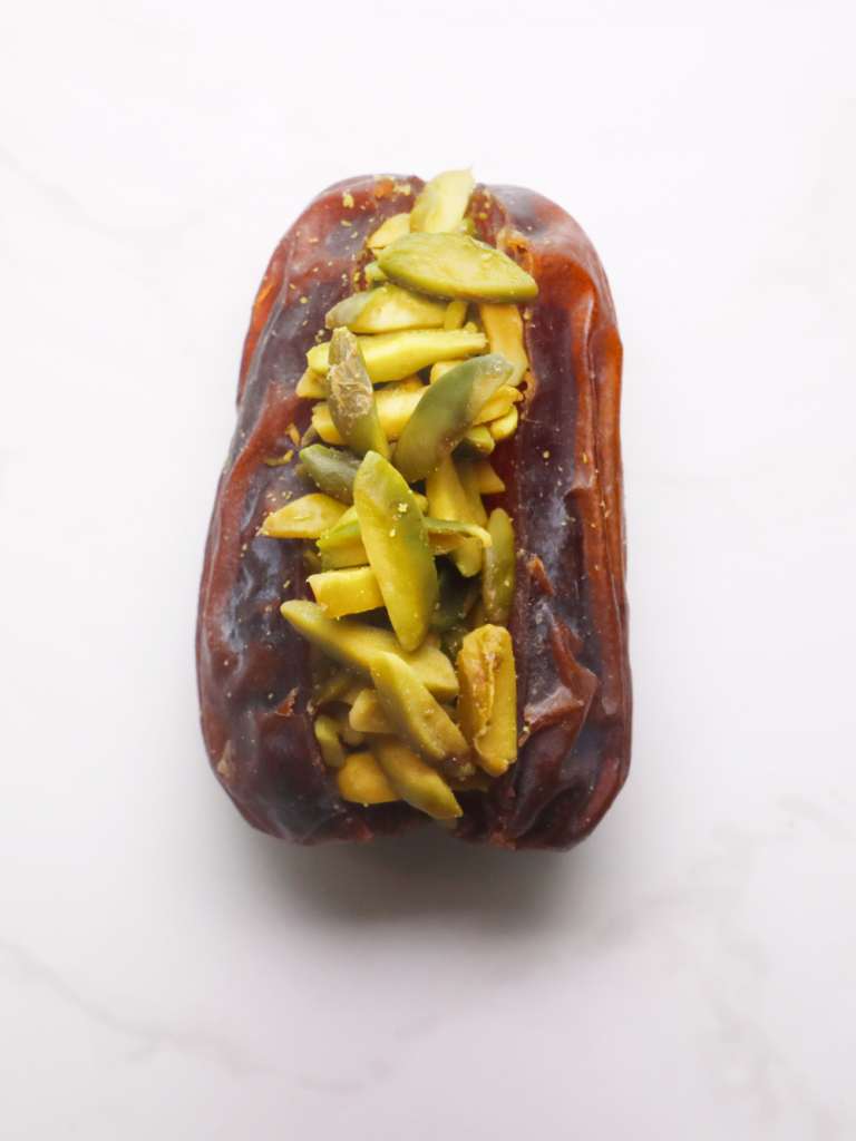 medjool date filled to the brim with vibrant green, crunchy slithers of pistachio